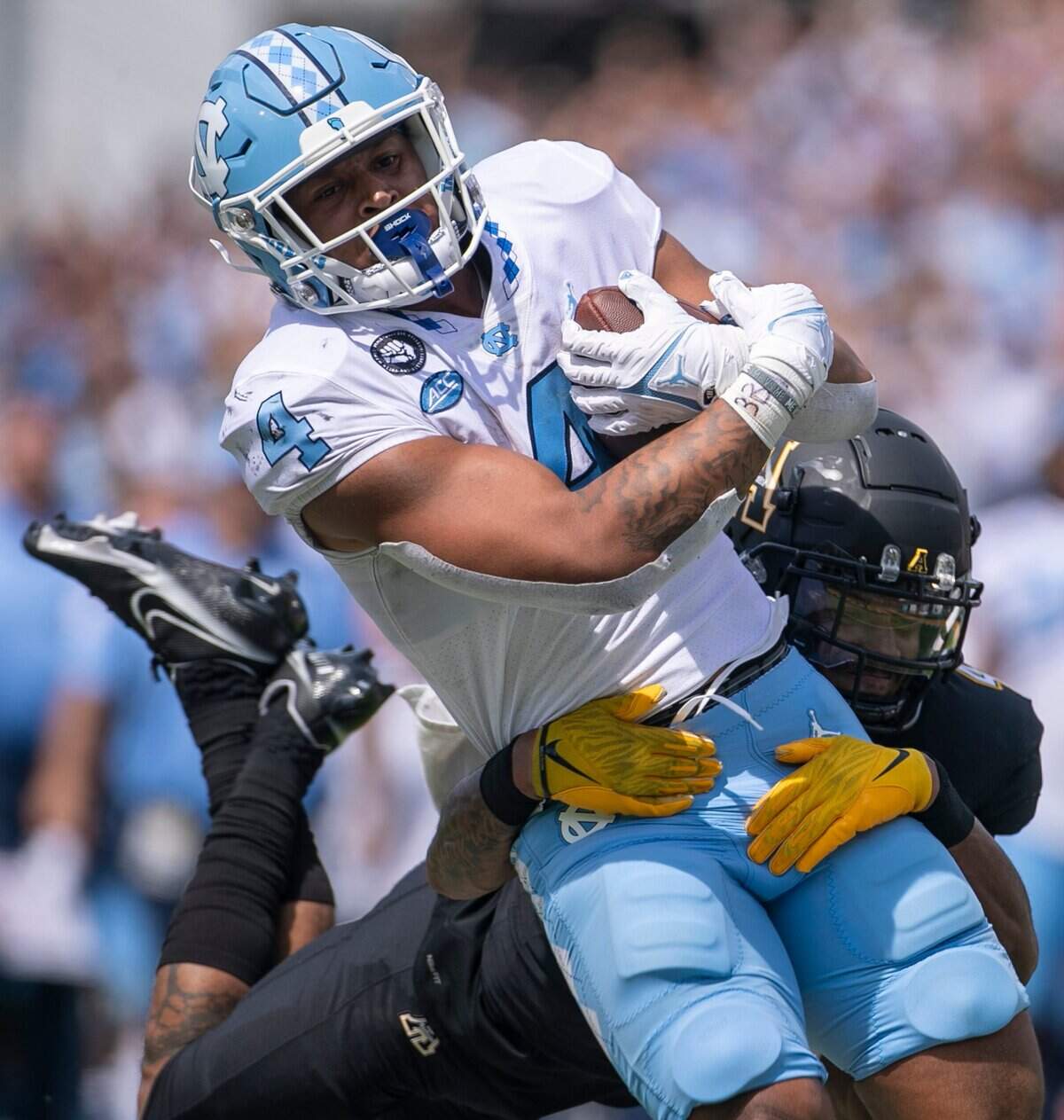 Appalachian States Nick Ross (4) stops North Carolinas Caleb Hood (4) after a 71-yard carry in the fourth quarter on Saturday, September 3, 2022 at Kidd Brewer Stadium in Boone, N.C.