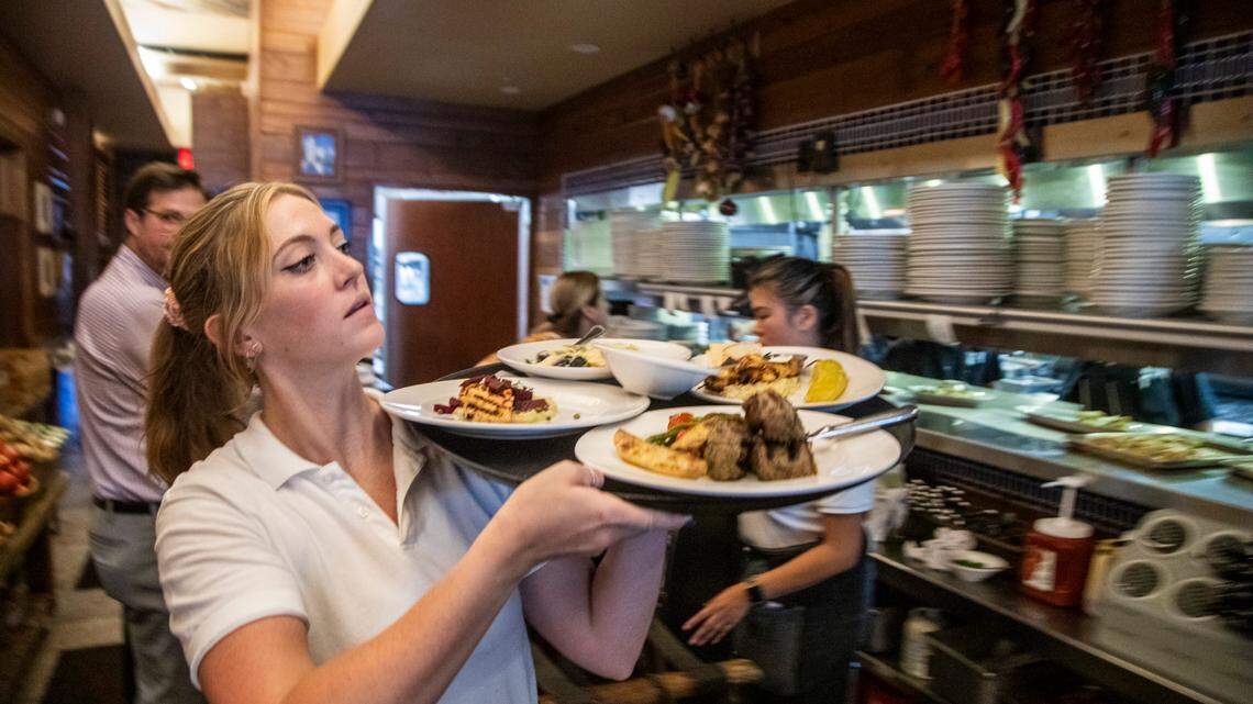 Server Charlotte Jones takes food to diners Wednesday, June 16, 2021 at Taverna Agora Greek Kitchen & Bar in Raleigh. Many restaurants say business is starting to return to normal as coronavirus restrictions have lifted but hiring remains a challenge.