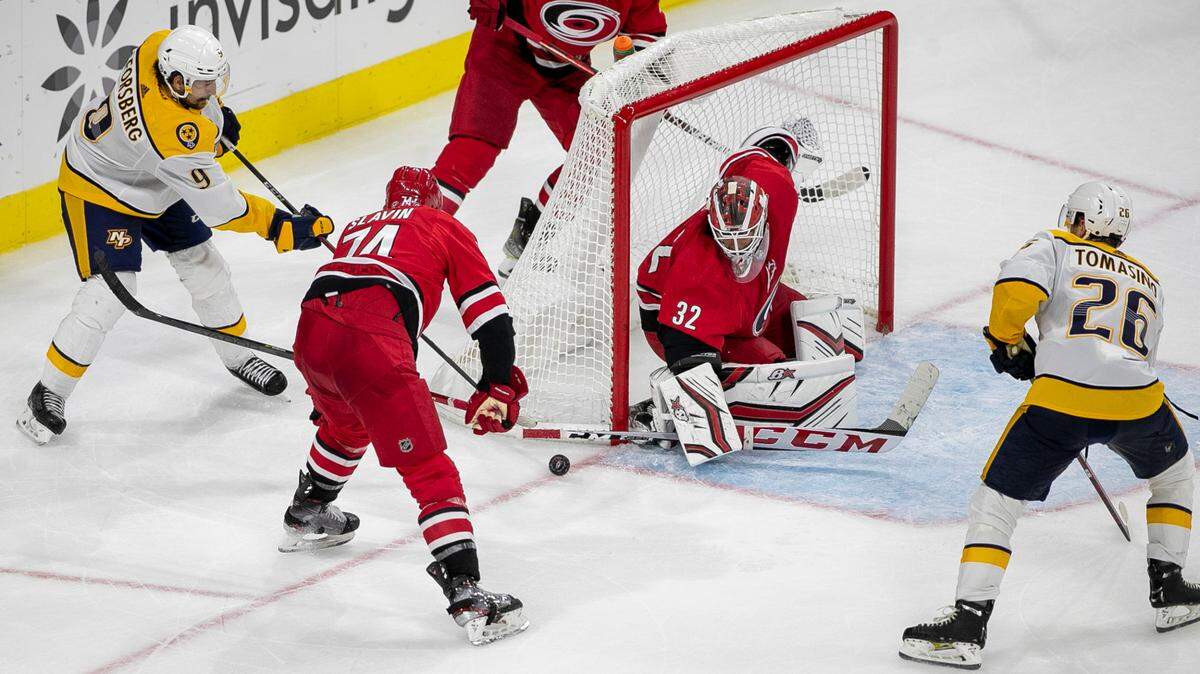 Carolina Hurricanes goalie Antii Raanta (32) deflects a shot by Nashville’s Filip Forsberg (9), setting up the game winning goal by Nashville’s Philip Tomasino (26) in overtime Tuesday, October 5, 2021 at PNC Arena in Raleigh, N.C.