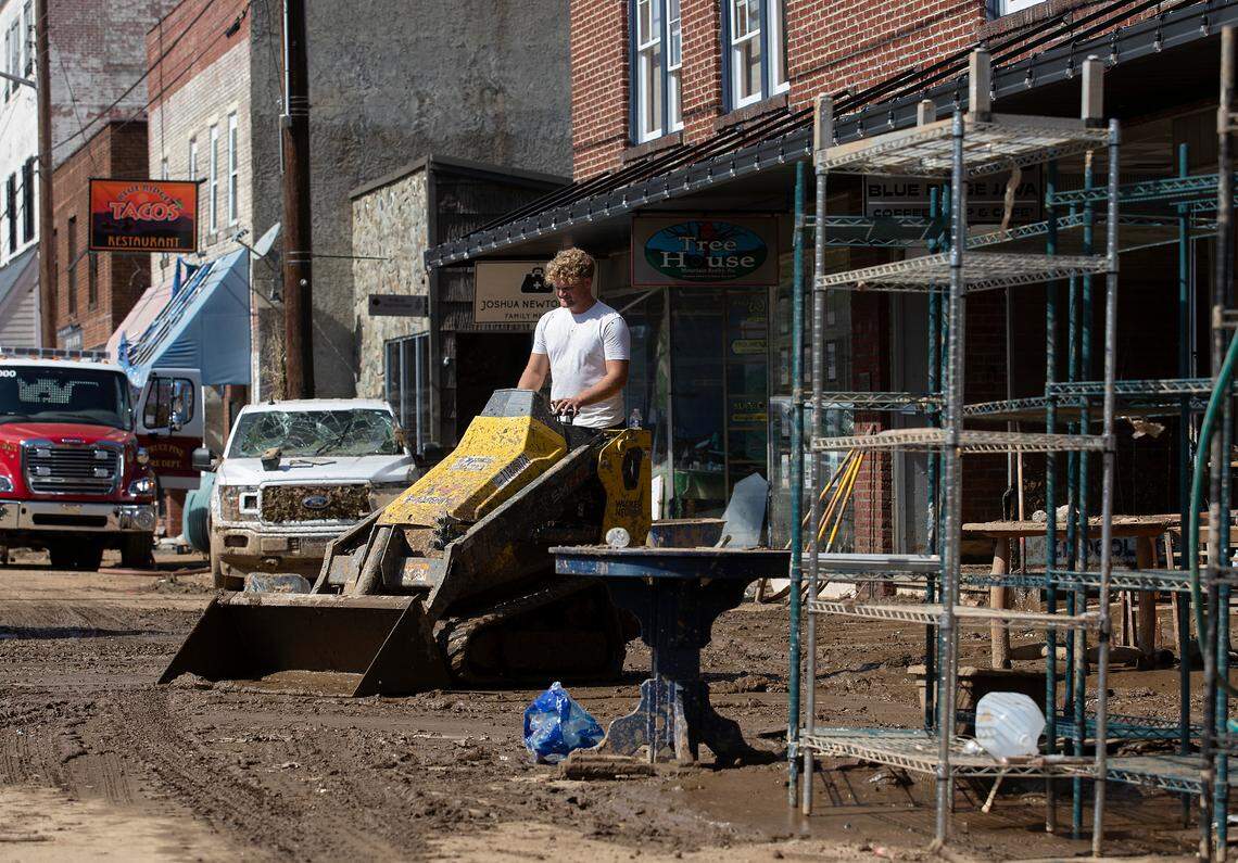 Marlin King, a volunteer from Pennsylvania, helps to clear mud and debris from Locust Street on Thursday, Oct. 3, 2024, in Spruce Pine, N.C. following damage from Hurricane Helene.