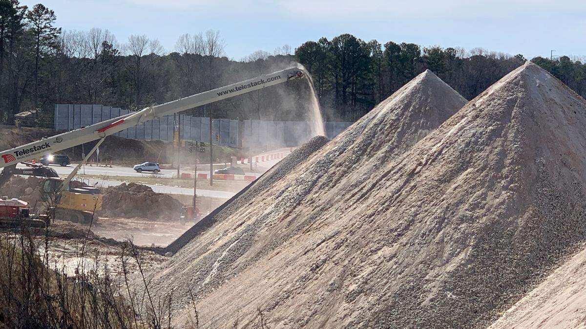 A conveyor belt moves pulverized concrete into piles at the Western Boulevard interchange with the Raleigh Beltline on Jan. 21, 2023. Nearby residents say the round-the-clock grinding operation creates noise and dust for their neighborhood.