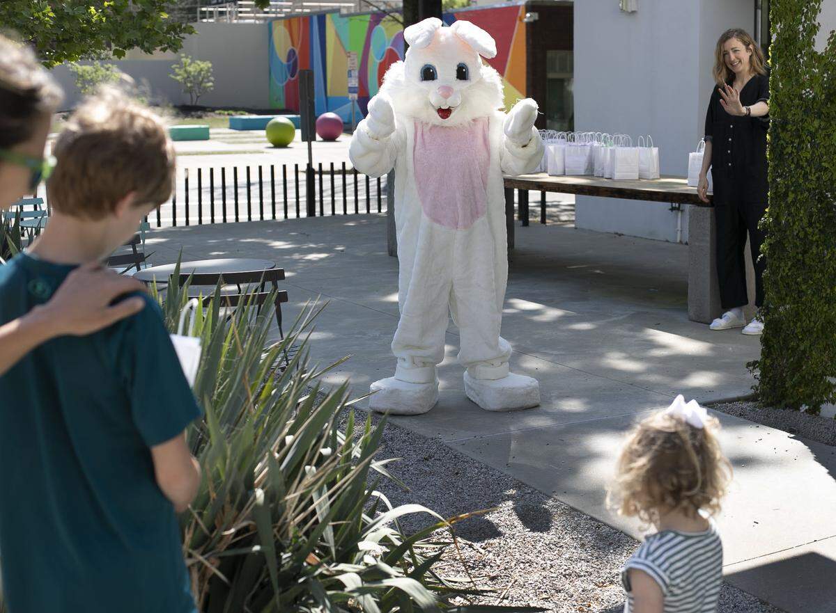 In this period of social distancing, the Easter Bunny keeps her distance from two-year-old Hattie Mac, after the Mac family came to pick up their Easter eggs from the Church on Morgan on Wednesday, April 8, 2020 in Raleigh, N.C. The Easter Bunny handed out more than 300 bags to children on Wednesday.