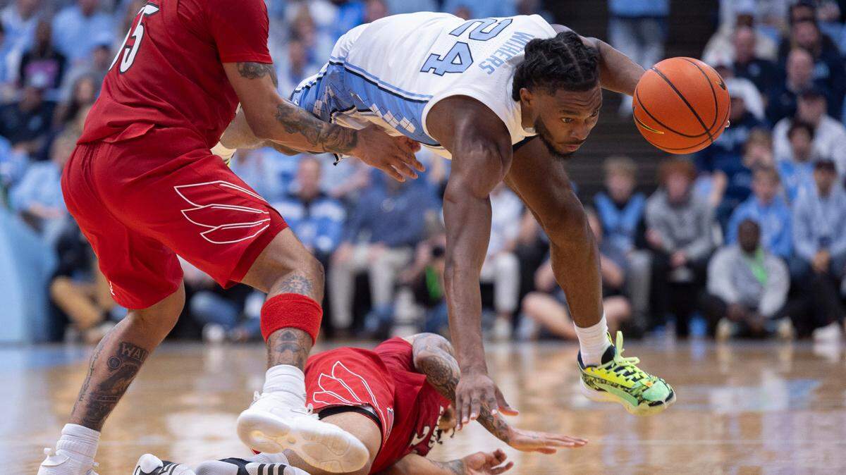 North Carolina’s Jae’Lyn Withers (24) recovers a loose ball over Louisville’s Tre White (22) in the second half on Wednesday, January 17, 2024 at the Smith Center in. Chapel Hill, N.C.