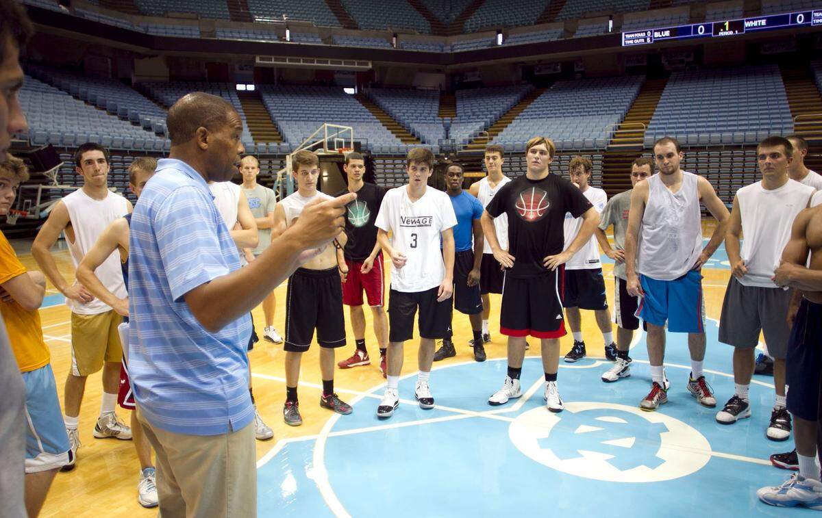 UNC Jayvee basketball coach Hubert Davis huddles with those trying out for the team on the first of two days of tryouts on Thursday October 3, 2013 at the Smith Center in Chapel Hill, N.C.