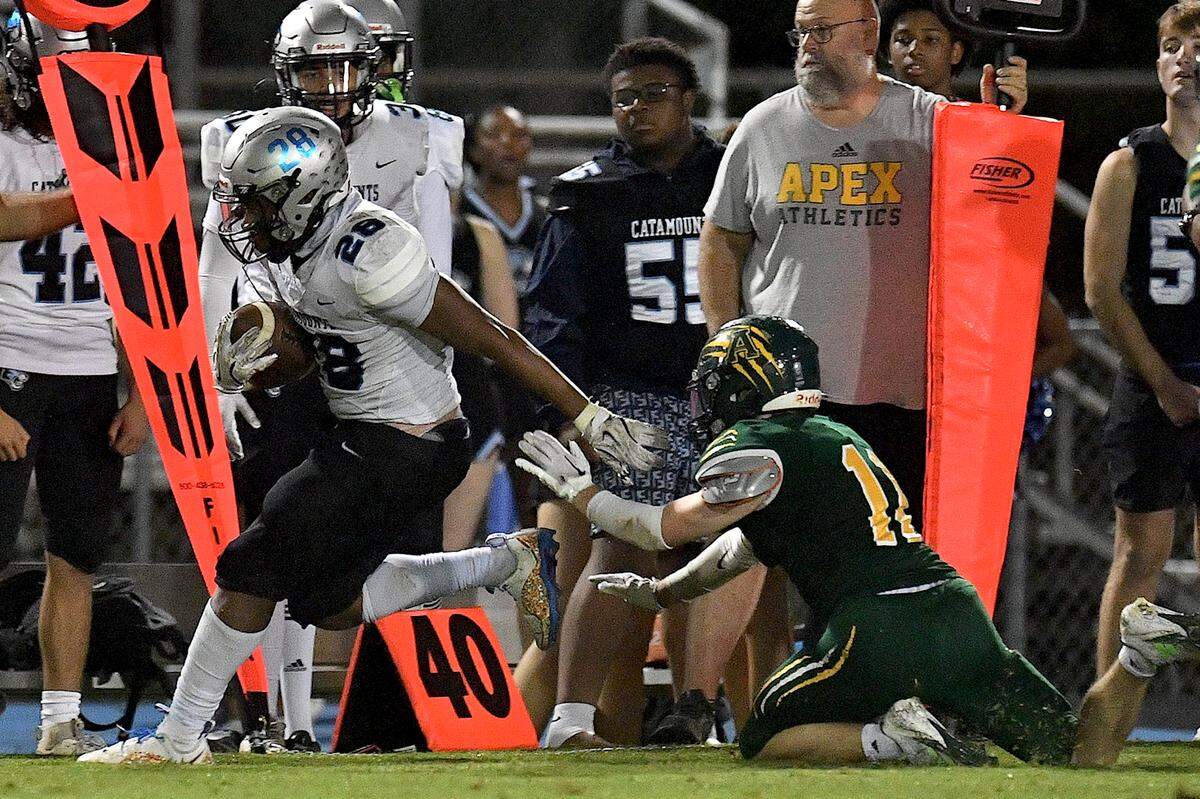 Panther Creek running back Travis Woodard (28) runs along the sidelines past Apex’s Tas Clayton (11) during the second half. The Apex Cougars and the Panther Creek Catamounts met in a conference football game in Apex, N.C. on September 20, 2024.