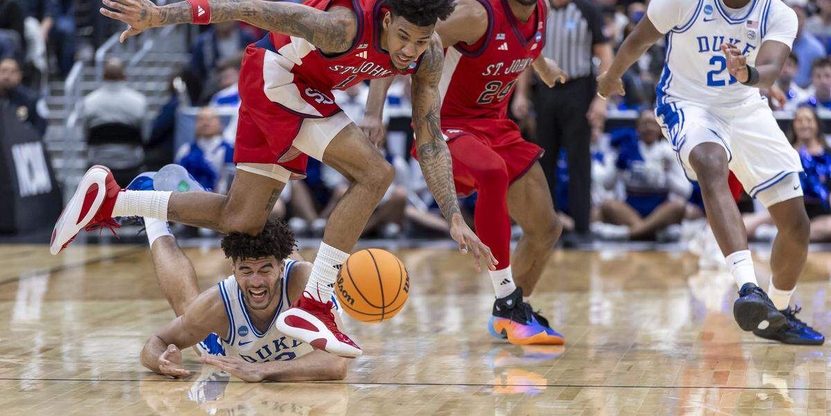 Duke forward Cameron Boozer (12) hits the court after turning the ball over under defensive pressure from St. John’s forward Dillon Mitchell (1) in the second half during the Sweet Sixteen of the NCAA Tournament on Friday, March 27, 2026, at Capital One Arena in Washington, D.C.