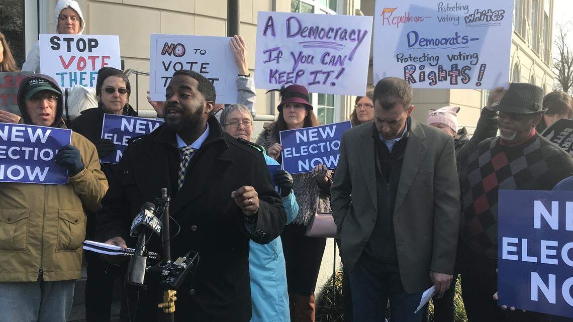 Marcus Bass, an organizer from the NC Black Alliance, speaks in front of fellow protesters Monday morning as they called for a new election in North Carolina’s 9th Congressional District. “We know the damage goes way further than just what meets the eye,” he said.