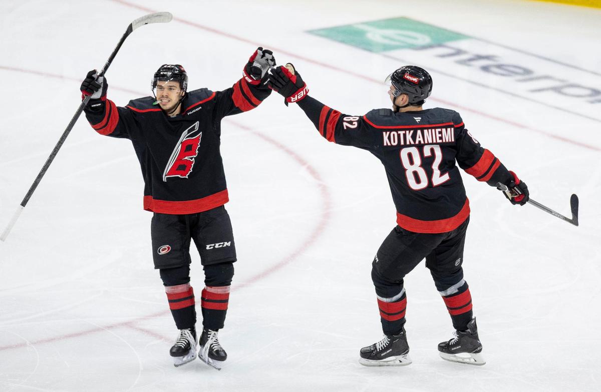 Carolina Hurricanes center Logan Stankoven (22) celebrates with Jesperi Kotkaniemi (82) after a goal by left wing Taylor Hall in the second period against the New Jersey Devils during Game 5 of their Stanely Cup series on Tuesday, April 29, 2025 at Lenovo Center in Raleigh, N.C.
