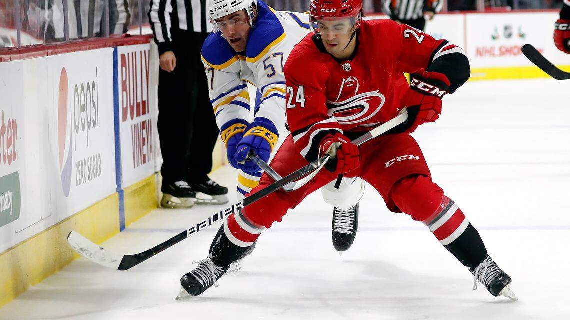 Carolina Hurricanes’ Seth Jarvis (24) tries to regain control of the puck in front of Buffalo Sabres’ Brett Murray (57) during the third period of an NHL hockey game in Raleigh, N.C., Saturday, Dec. 4, 2021. (AP Photo/Karl B DeBlaker)