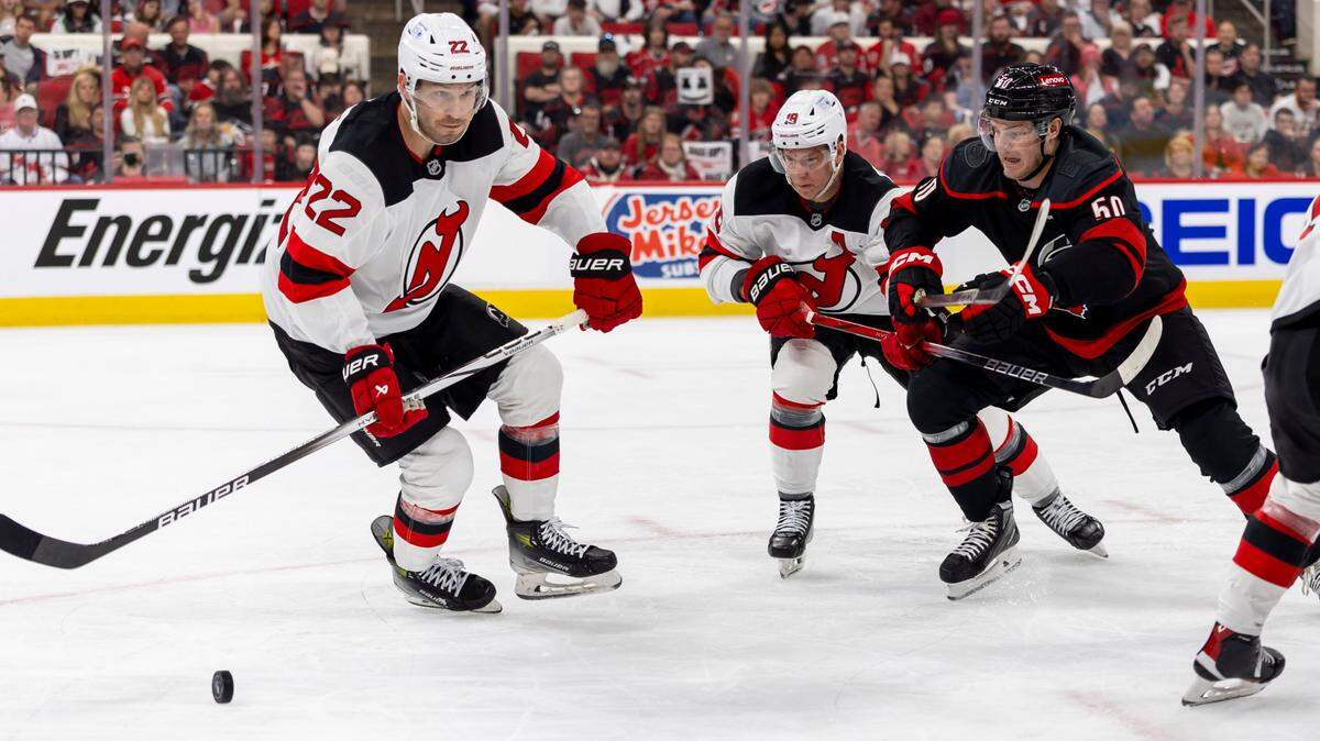 New Jersey DevilsÕ defenseman Bret Pesce (22), left wing Ondrej Palat (18) and Carolina Hurricanes left wing Eric Robinson (50) battle for control of the puck during the first period on Sunday, April 20, 2025 at Lenovo Center in Raleigh, N.C.
