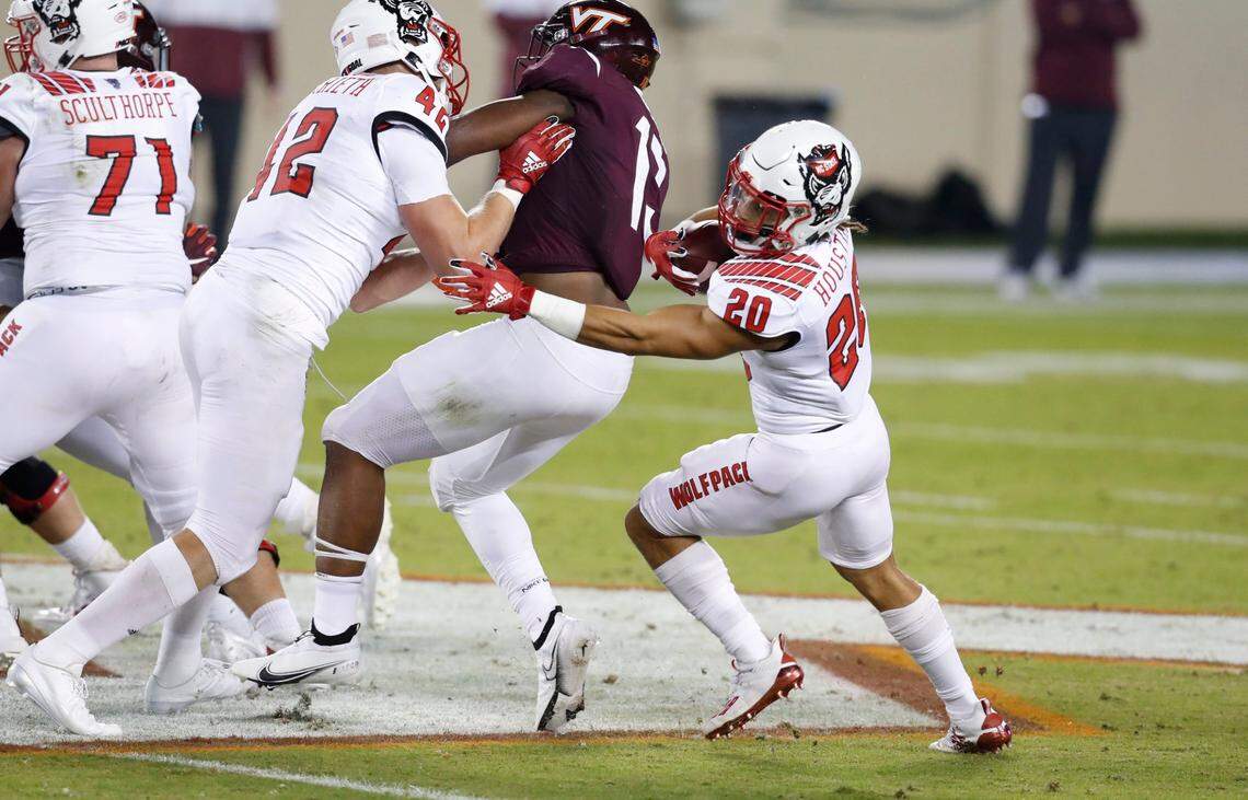 N.C. State running back Jordan Houston (20) runs around Virginia Tech defensive back Divine Deablo (17) as tight end Dylan Autenrieth (42) provides the block during the first half of N.C. State’s game against Virginia Tech at Lane Stadium in Blacksburg, VA Saturday, Sept. 26, 2020.