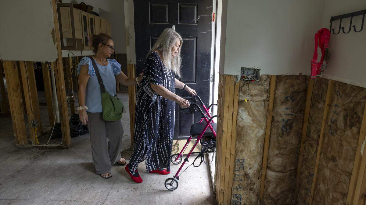 Jennifer Johnson and her mother, Steffi Cooper, leave their flood damaged home in the Weatherhill Pointe neighborhood of Carrboro after a visit on Tuesday, Aug. 19.