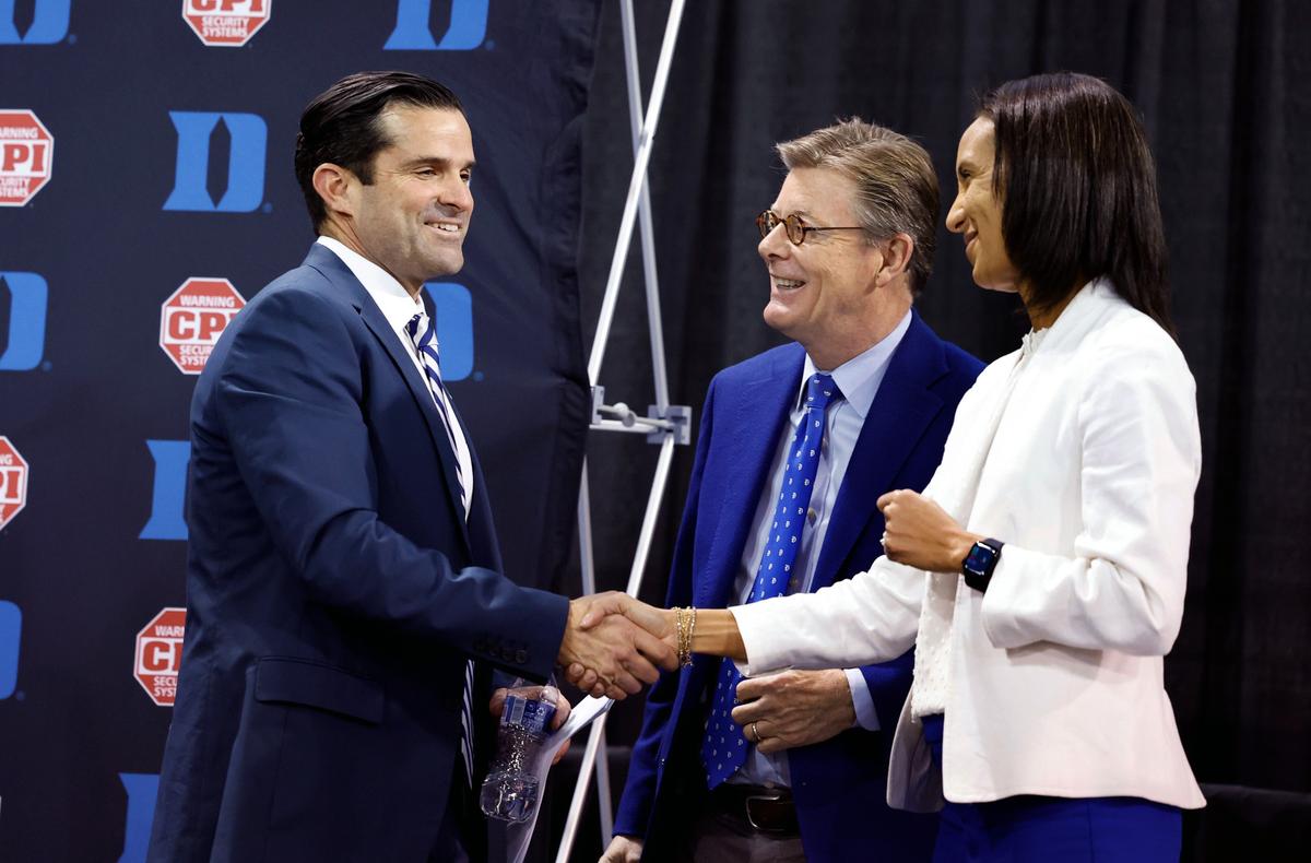 New Duke head football coach Manny Diaz talks with Duke President Vincent Price and athletics director Nina King after a press conference at Pascal Field House in Durham, N.C., Saturday, Dec. 9, 2023.