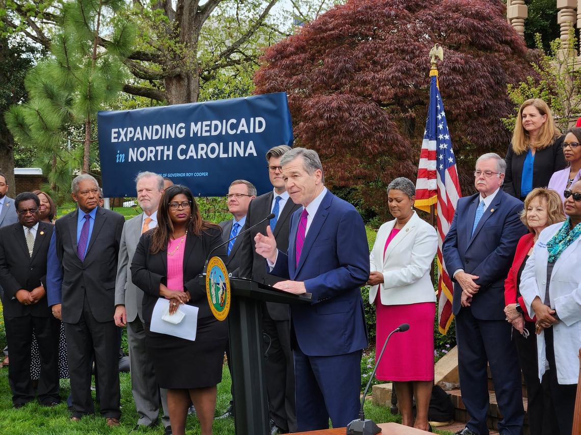 Democratic Gov. Roy Cooper speaks to a crowd of people outside the Executive Mansion shortly before signing Medicaid expansion into law Monday, March 27, 2023.. He was joined by a bipartisan group of legislators.