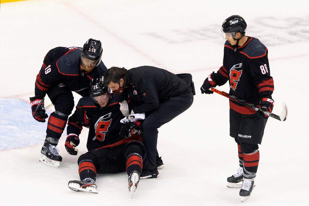 Carolina Hurricanes’ Andrei Svechnikov is helped up after being injured against the Boston Bruins during third period NHL Eastern Conference Stanley Cup playoff game in Toronto on Saturday, Aug. 15, 2020. (Chris Young/The Canadian Press via AP)