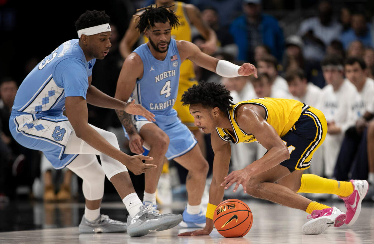 Michigan’s Kobe Bufkin (2) is trapped by North Carolina’s Jalen Washington (13) and R.J. Davis (4) in the first half on Wednesday, December 21, 2022 at the Spectrum Center in Charlotte, N.C.
