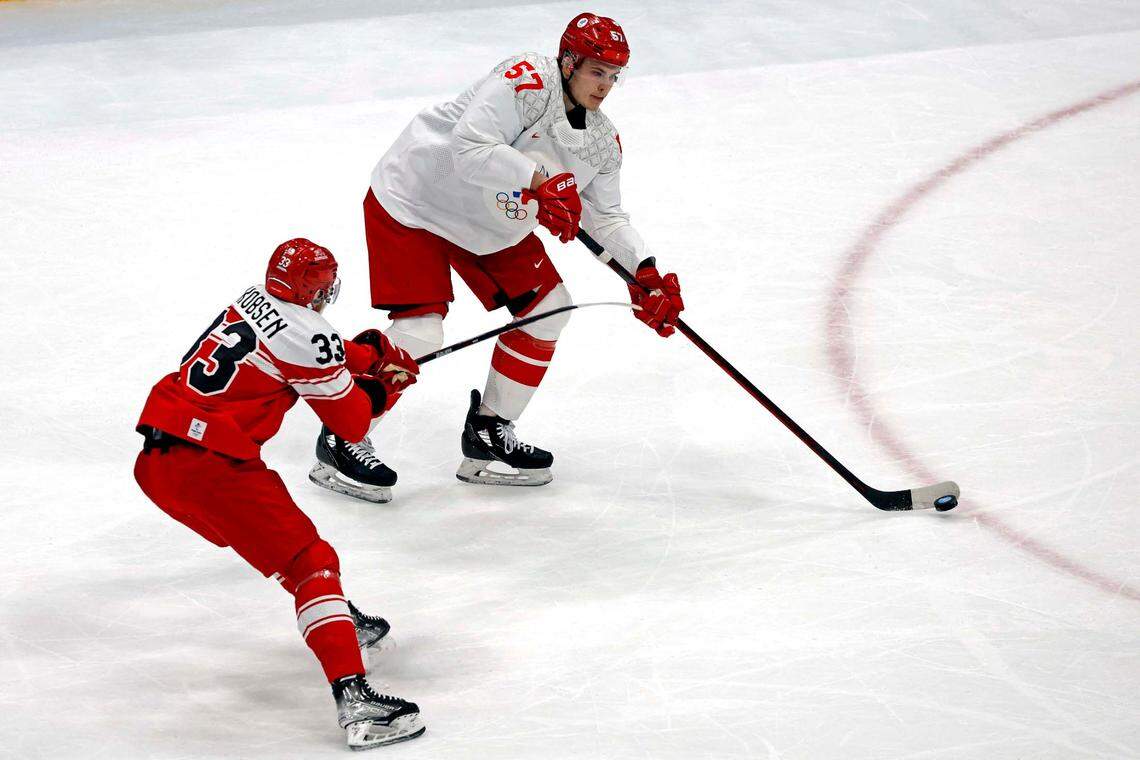 Feb 11, 2022; Beijing, China; ROC defender Alexander Nikishin (57) passes the puck against Denmark forward Julian Jakobsen (33) in men’s ice hockey Group B play during the Beijing 2022 Olympic Winter Games at National Indoor Stadium. Mandatory Credit: Peter Casey-USA TODAY Sports