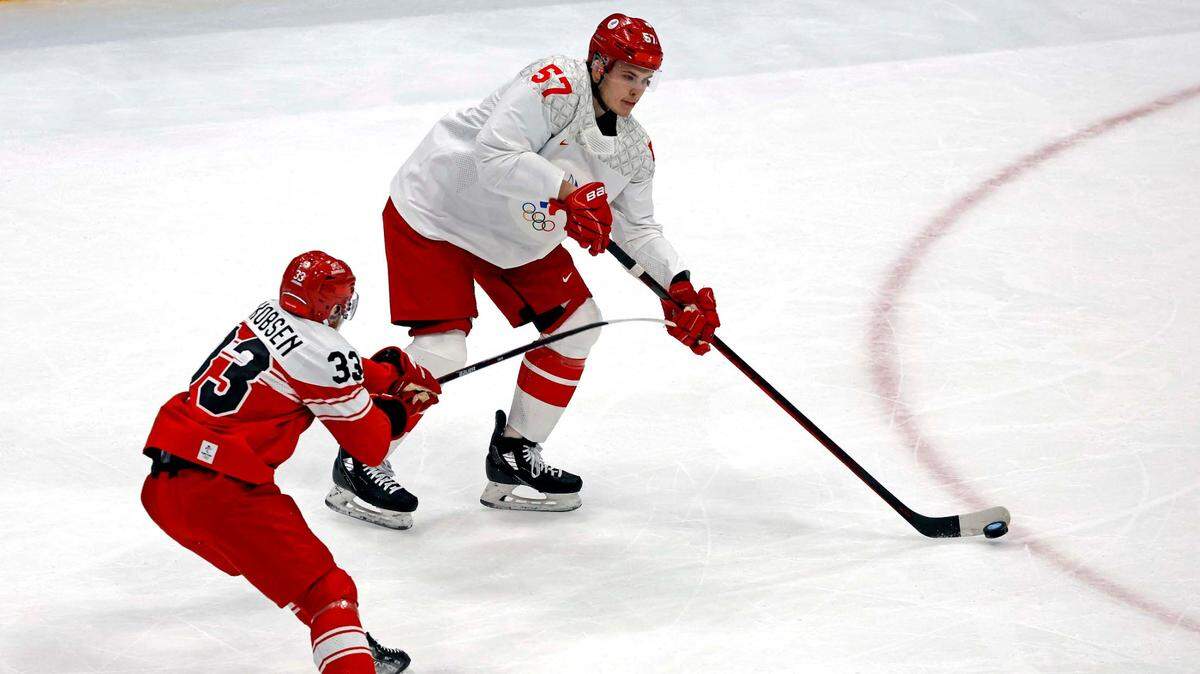 Feb 11, 2022; Beijing, China; ROC defender Alexander Nikishin (57) passes the puck against Denmark forward Julian Jakobsen (33) in men’s ice hockey Group B play during the Beijing 2022 Olympic Winter Games at National Indoor Stadium. Mandatory Credit: Peter Casey-USA TODAY Sports