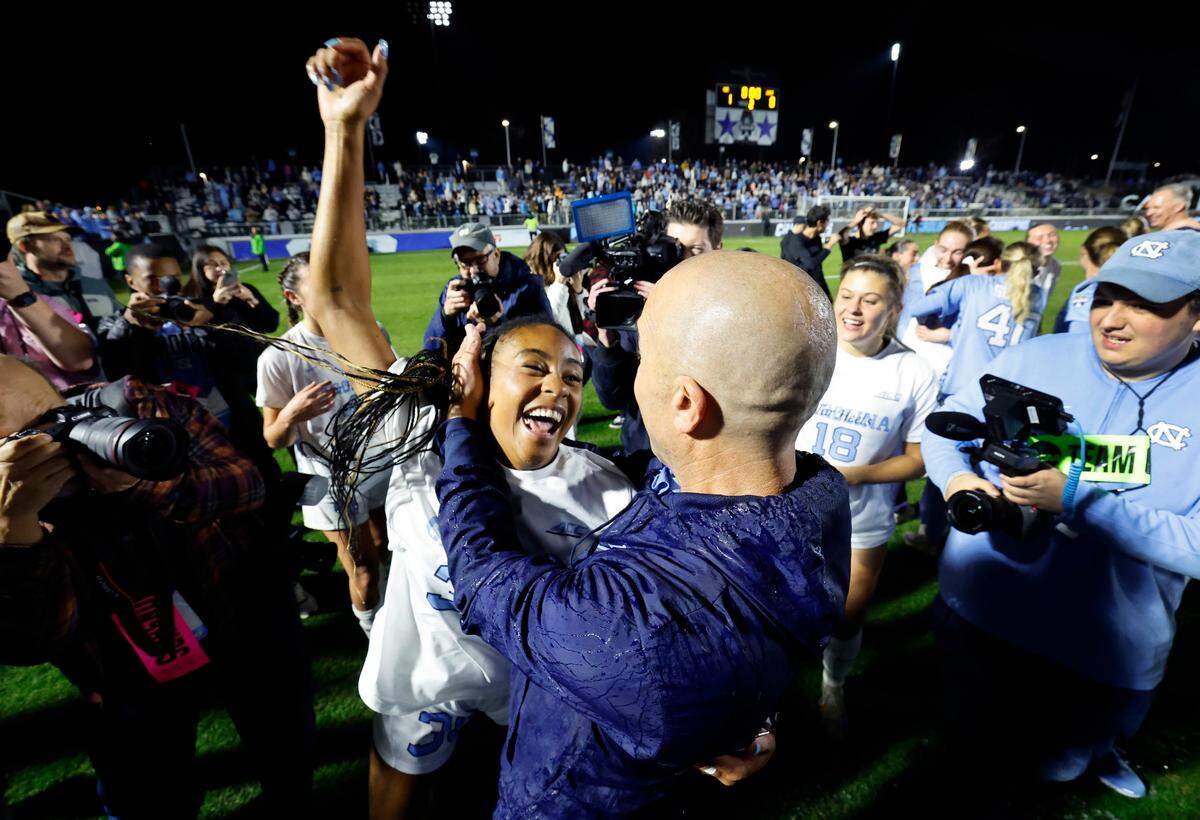 North Carolina head coach Damon Nahas celebrates with Asha Means (39) after UNC’s 1-0 victory over Wake Forest in the finals of the 2024 Women’s College Cup at WakeMed Soccer Park in Cary, N.C., Monday, Dec. 9, 2024.