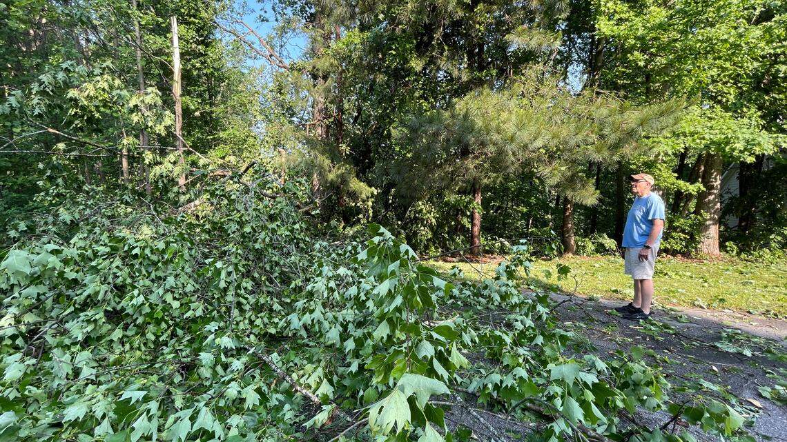 Jim Pennington looks at a tree that fell from his yard across High Mountain Road, making the road impassible, in Garner during overnight storms Friday morning, May 20, 2022.