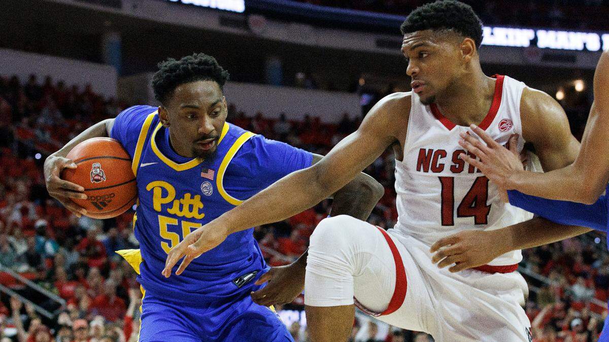 Pittsburgh’s Zack Austin pulls down a rebound away from N.C. State’s Casey Morsell during the second half of the Wolfpack’s 67-64 loss on Wednesday, Feb. 7, 2024, at PNC Arena in Raleigh, N.C.