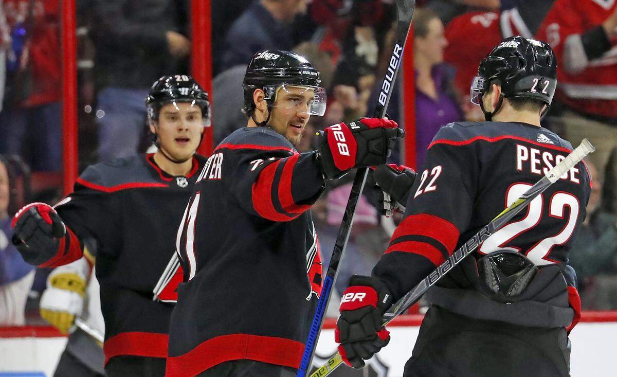 Carolina Hurricanes’ Nino Niederreiter, center, celebrates his goal with teammates Sebastian Aho, left, and Brett Pesce (22) during the first period of an NHL hockey game against the Vegas Golden Knights, Friday, Feb. 1, 2019, in Raleigh, N.C.