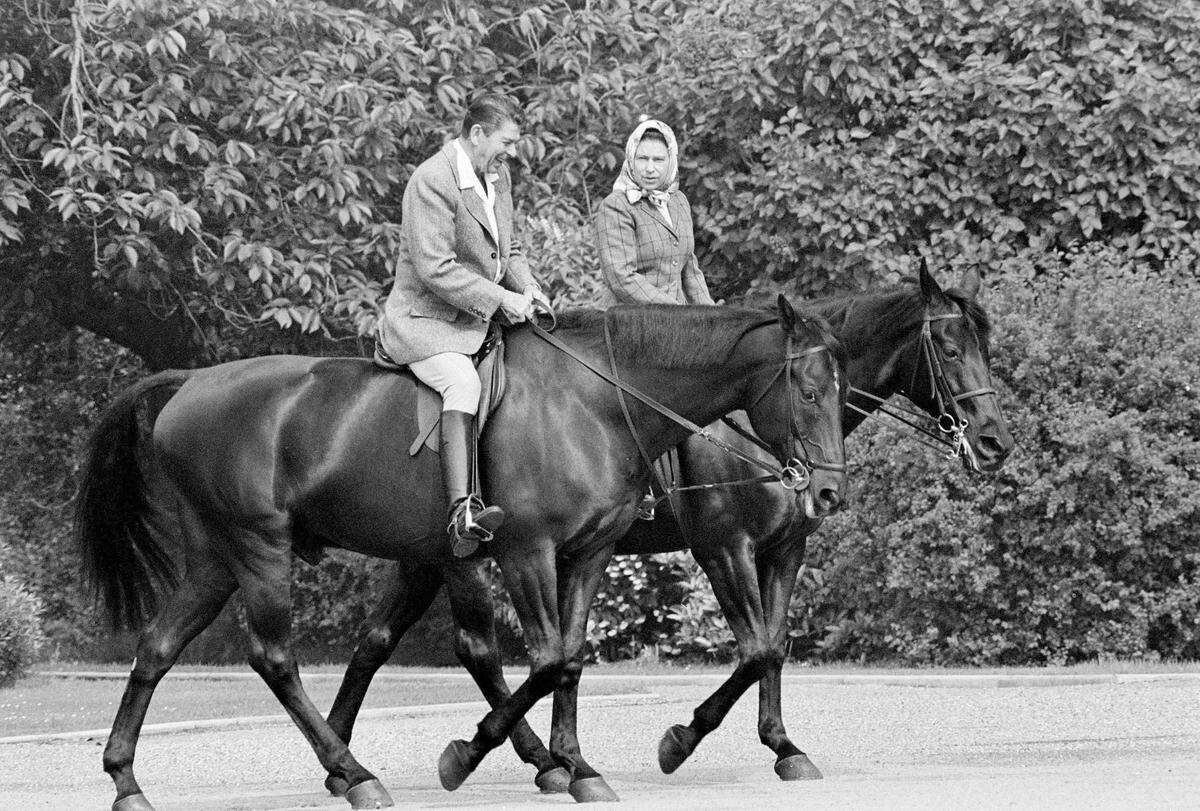 In this June 8, 1982 file photo, U.S. President Ronald Reagan, on Centennial, and Britain’s Queen Elizabeth II, on Burmese, go horseback riding in the grounds of Windsor Castle, England.