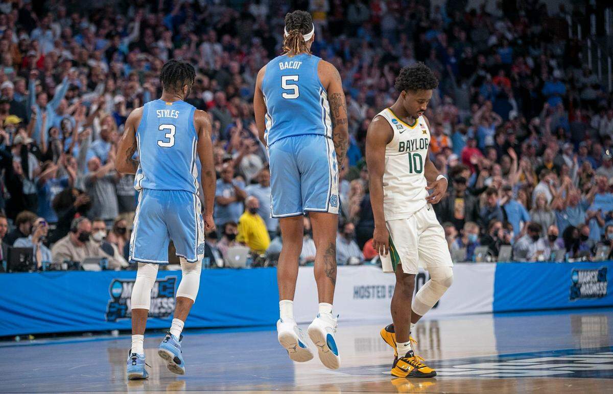 North Carolinas Armando Bacot (5) and Dontrez Styles (3) turn toward the Tar Heels fans base to celebrate their 93-86 victory as time expires in the overtime period and Baylors Adam Flagler (10) leaves the court on Saturday, March 19, 2022 during the NCAA Tournament at Dickies Arena in Ft. Worth, TX.