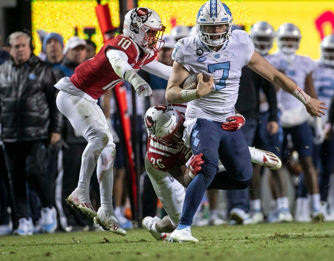 N.C. State’s Devon Betty (26) stops North Carolina quarterback Sam Howell (7) after a 24-yard gain in the fourth quarter on Friday, November 26, 2021 at Carter-Finley Stadium in Raleigh, N.C.