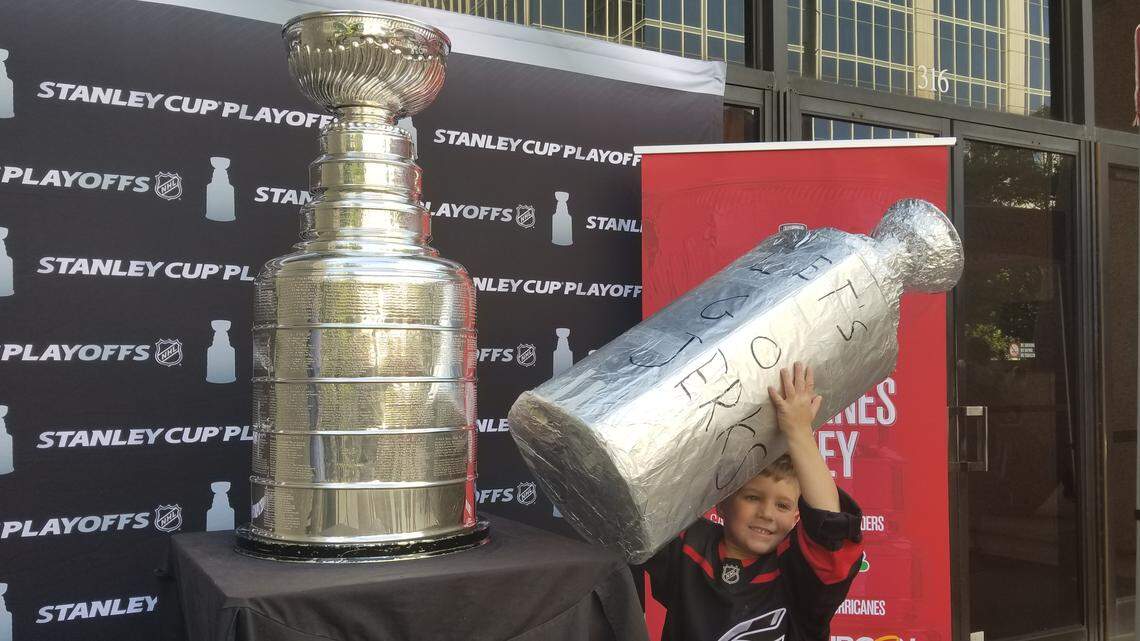 Oliver Dedene, 5, holds up his own homemade Stanley Cup with the real Stanley Cup on April 27, 2019, in downtown Raleigh.