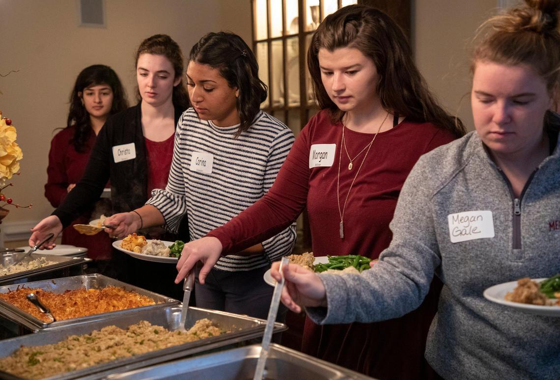 Students fill their plates with traditional holiday dishes during an annual Thanksgiving lunch hosted by Meredith College president Jo Allen at her home for students who stay on campus for the holiday, on Wednesday, 27, 2019, in Raleigh, NC.