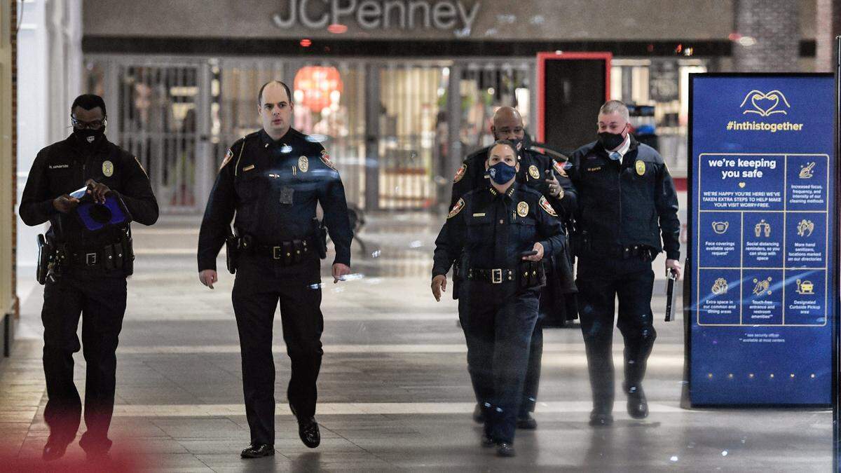 Durham police officers, including chief Patrice Andrews (third from left) walk through the Streets of Southpoint mall in Durham, N.C. after a shooting Friday afternoon, Nov. 26, 2021, left three people wounded, including a 10-year-old. The shooting resulted in an evacuation Black Friday shoopers at the mall.