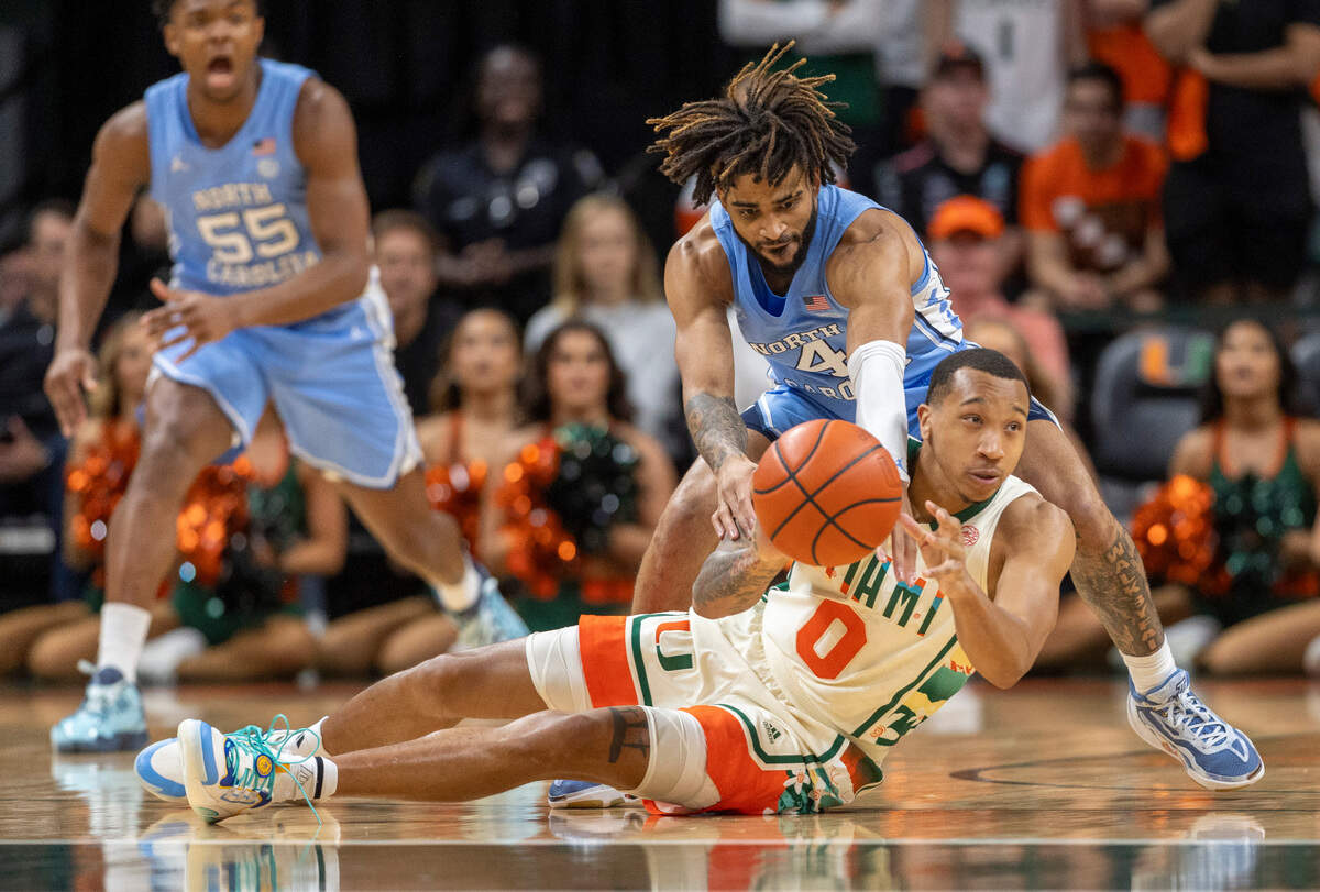 North Carolina’s R.J. Davis (4) tries for a steal from Miami’s Matthew Cleveland (0) in the first half on Saturday, February 10, 2024 at the Watsco Center in Coral Gables, Florida.