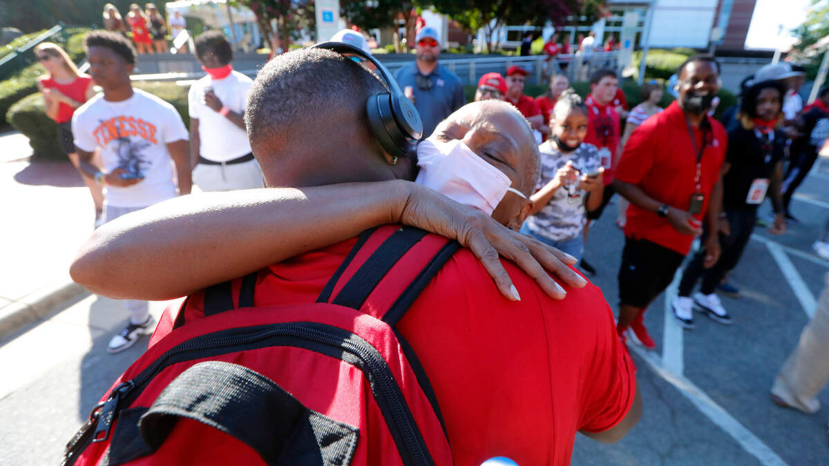 N.C. State’s Tyler Baker-Williams hugs his mother Jonnita Baker-Williams during the Walk of Champions before the Wolfpack’s game against South Florida at Carter-Finley Stadium in Raleigh, N.C., Thursday, Sept. 2, 2021.