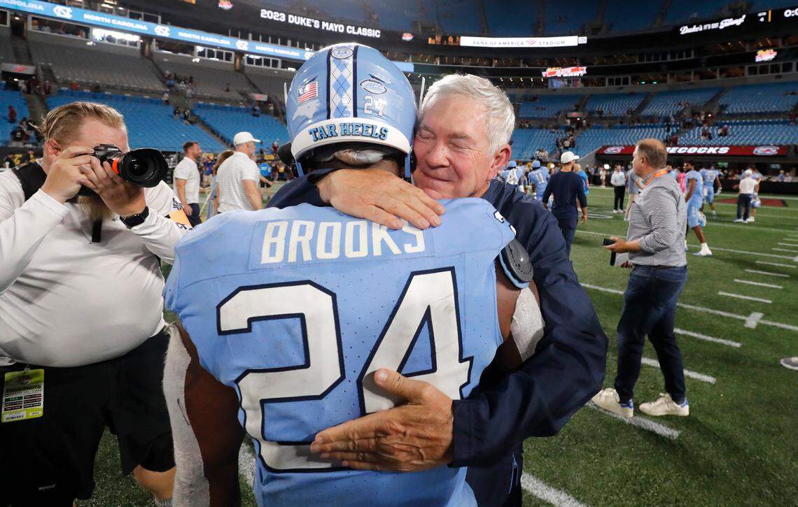 North Carolina head coach Mack Brown hugs running back British Brooks (24) after UNC’s 31-17 victory over South Carolina in the Duke’s Mayo Classic at Bank of America Stadium in Charlotte, N.C., Saturday, Sept. 2, 2023.