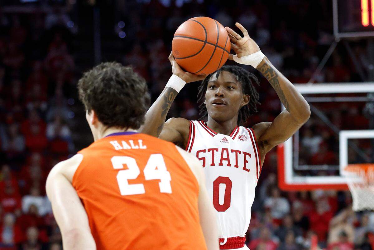 N.C. State’s Terquavion Smith (0) shoots as Clemson’s PJ Hall (24) defends during the first half of N.C. State’s game against Clemson at PNC Arena in Raleigh, N.C., Saturday, Feb. 25, 2023.