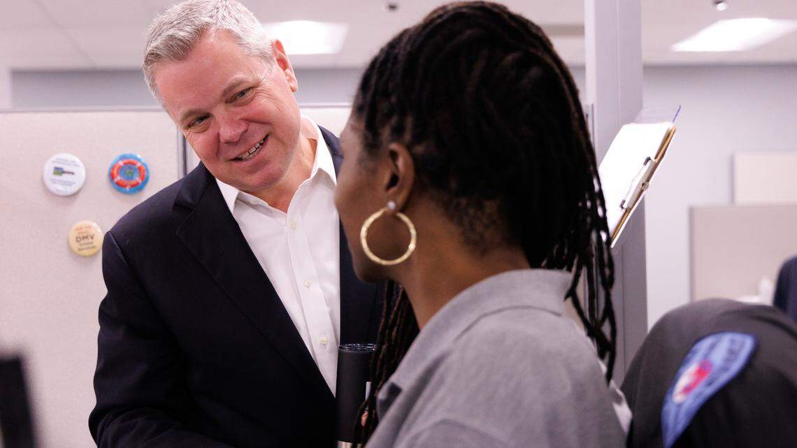 DMV Commissioner Paul Tine greets LaKishia Bell, a drivers license examiner at the DMV East Raleigh office, on Friday, May 9, 2025.