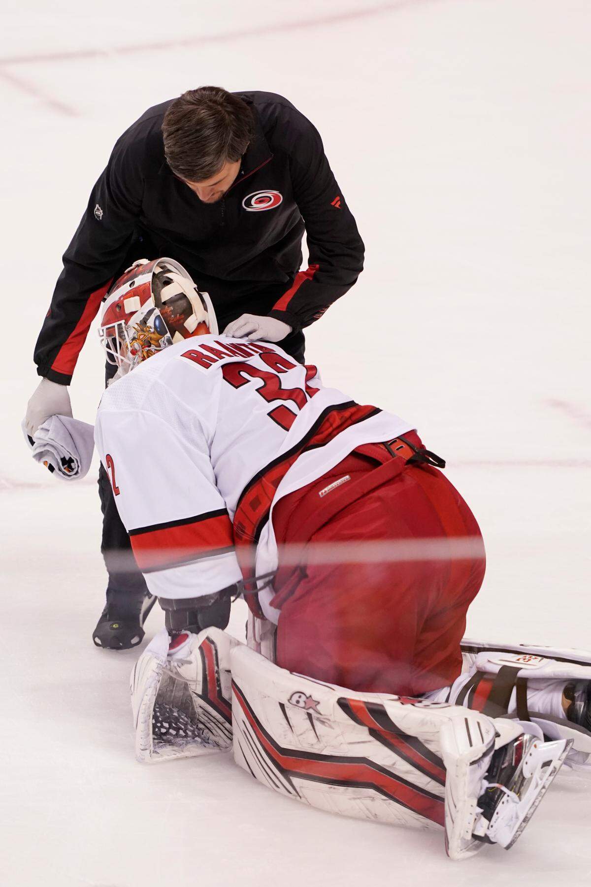 Carolina Hurricanes goaltender Antti Raanta (32) is assisted on the ice after he was injured in a collision with Florida Panthers left wing Ryan Lomberg during the second period at an NHL hockey game, Saturday, Nov. 6, 2021, in Sunrise, Fla. (AP Photo/Marta Lavandier)