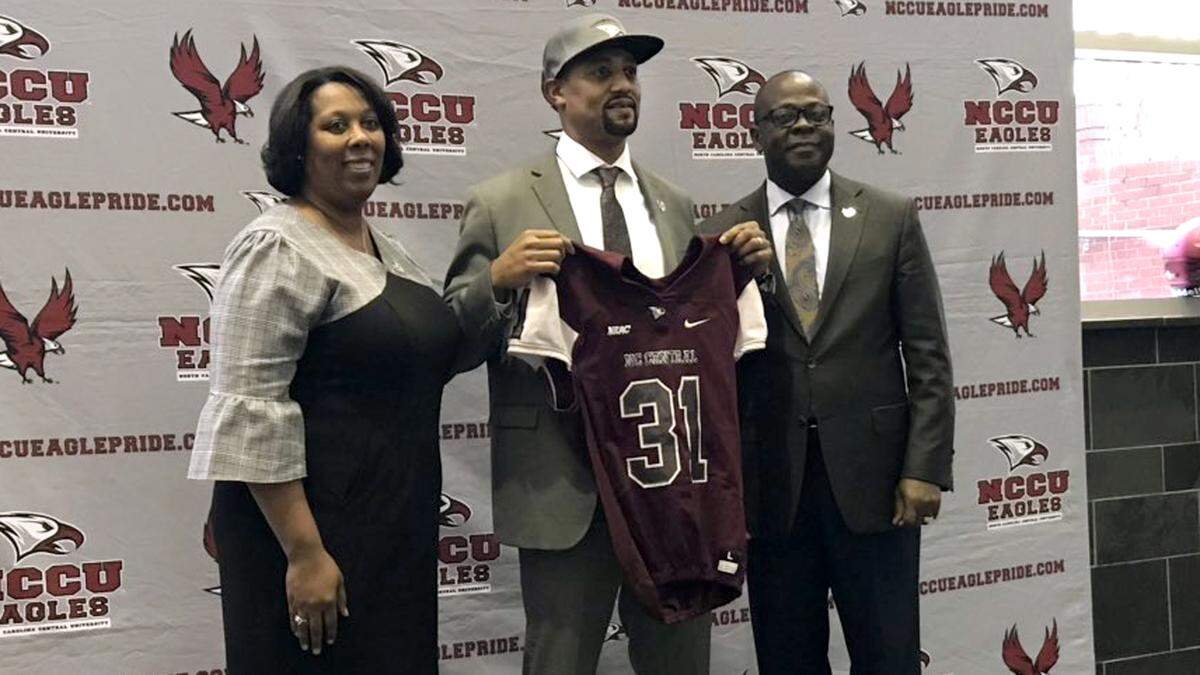 New NCCU football coach Trei Oliver, center, poses with director of athletics Ingrid Wicker-McCree, left, and Johnson O. Akinleye Thursday, Dec. 13, 2018, at North Carolina Central University.
