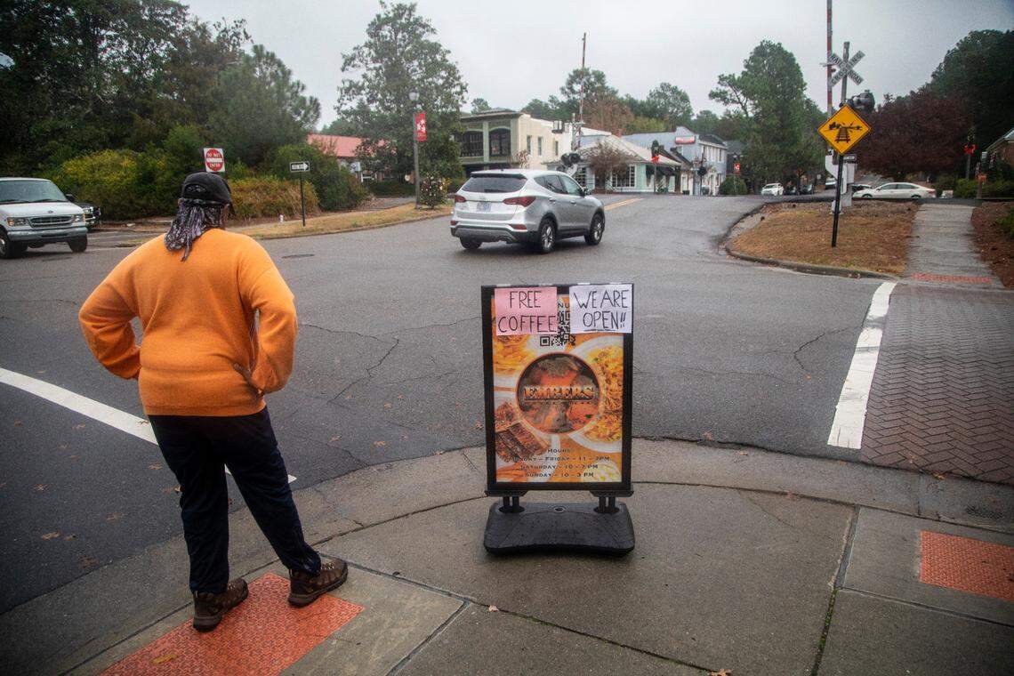 A sign advertises free coffee Wednesday, Dec. 7, 2022 as businesses began to open their doors after power was restored in downtown Southern Pines. Two deliberate attacks on electrical substations in Moore County Saturday evening caused days-long power outages for tens of thousands of customers. 