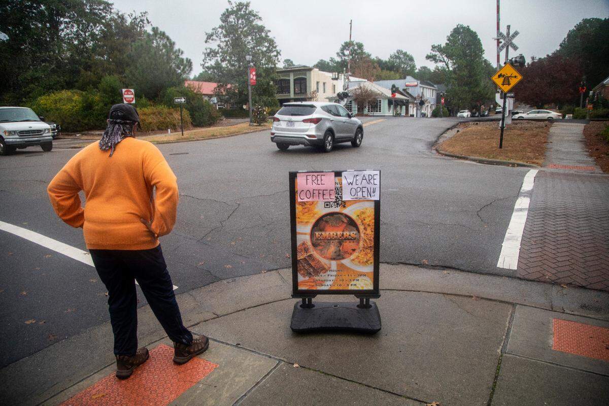 A sign advertises free coffee Wednesday, Dec. 7, 2022 as businesses began to open their doors after power was restored in downtown Southern Pines. Two deliberate attacks on electrical substations in Moore County Saturday evening caused days-long power outages for tens of thousands of customers. 