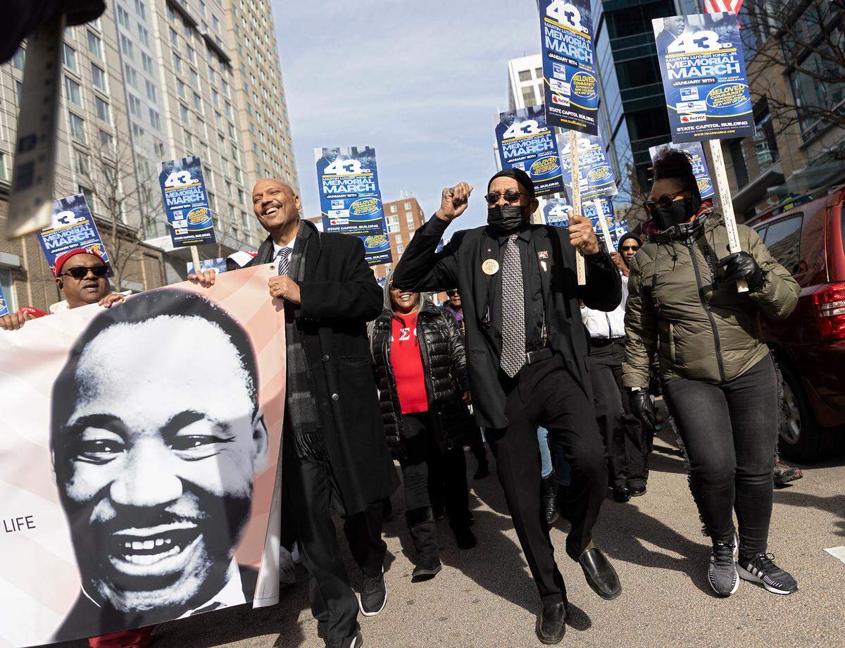 People walk along Fayetteville Street during the Martin Luther King, Jr. Memorial March on Monday, Jan. 16, 2023, in Raleigh, N.C.