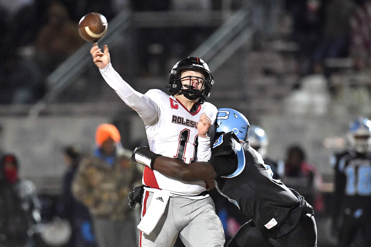 Rolesville quarterback Braden Atkinson (11) launches the pass against the tackle from Cleveland linebacker Jaylen King (9) during the first half. The Rolesville Rams and the Cleveland Rams met in the fourth round of the NCHSAA 4A football playoffs in Clayton, N.C. on December 6, 2024.