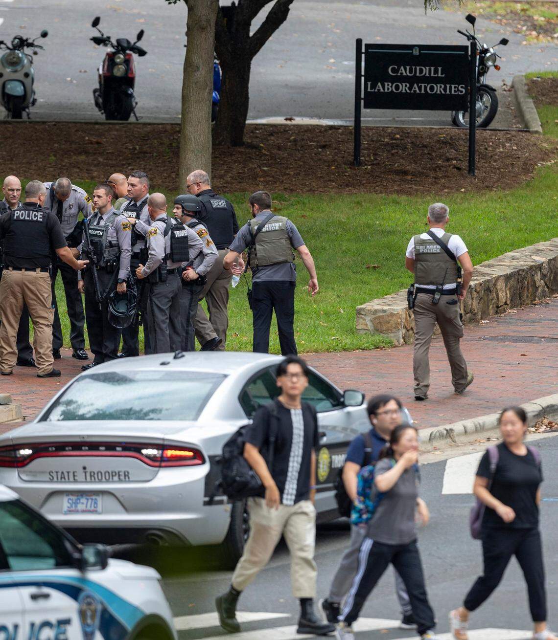 North Carolina State Troopers confer with fellow law enforcement officers outside the Caudill Labs building near the Bell Tower on the University of North Carolina campus after a report of an armed and dangerous person on Monday, August 28. 2023 in Chapel Hill, N.C.