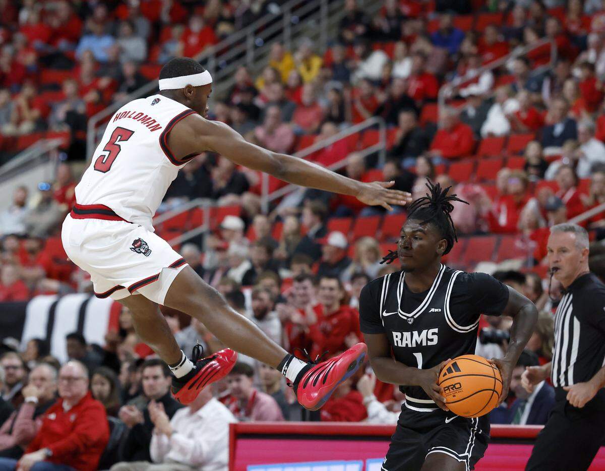 N.C. State’s Tre Holloman defends VCU’s Nyk Lewis during the first half of the Wolfpack’s game on Monday, Nov. 17, 2025, at the Lenovo Center in Raleigh, N.C.