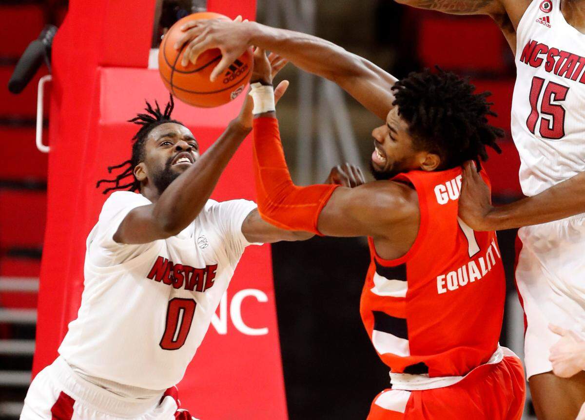 N.C. State’s D.J. Funderburk (0) fights for the rebound with Syracuse’s Quincy Guerrier (1) during the second half of Syracuse’s 77-68 victory over N.C. State at PNC Arena in Raleigh, N.C., Tuesday, February 9, 2021.