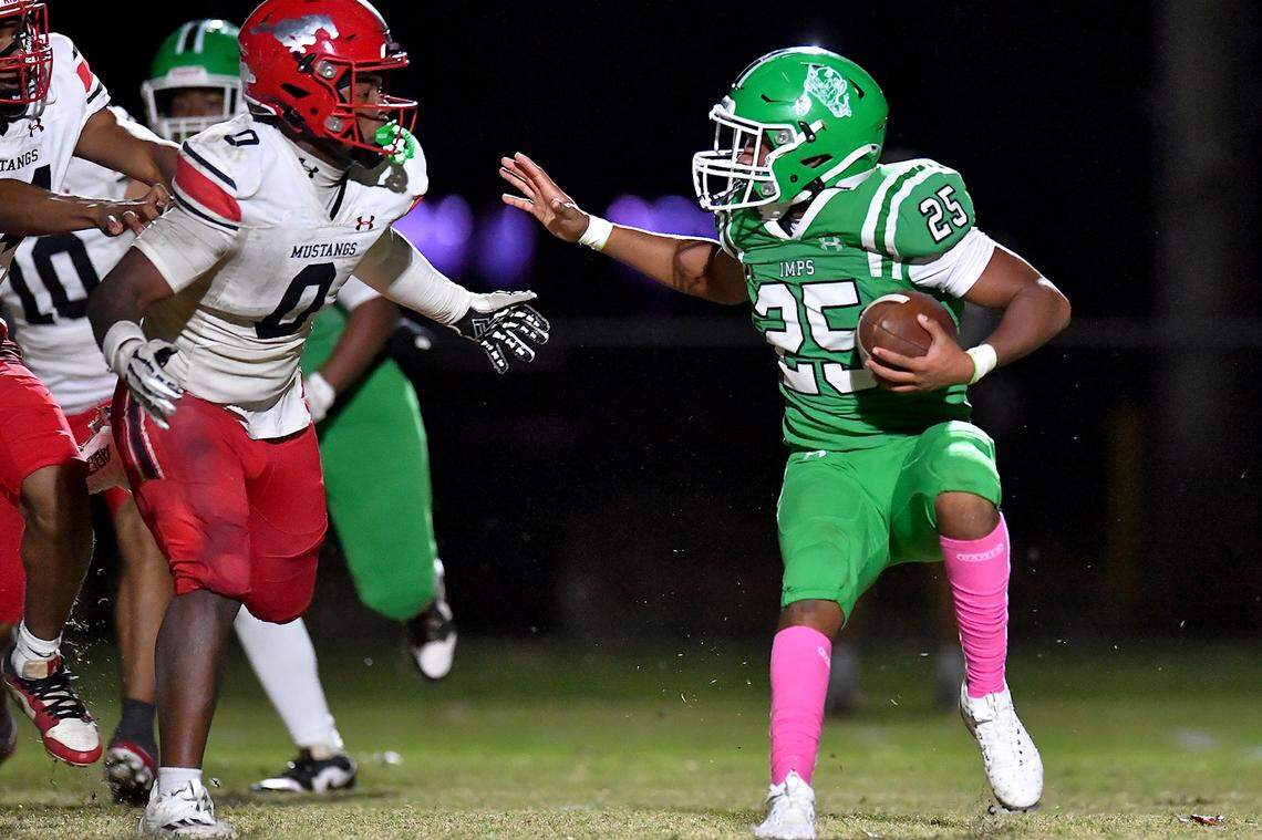 Cary's Skylan Joyner (25) looks for running room against Middle Creek's Jayden Spencer (0) during the first half. The Cary Imps and the Middle Creek Mustangs met in a conference football game in Cary, N.C. on October 24, 2025