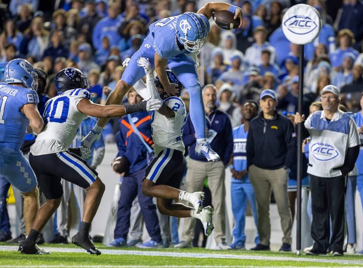 North Carolina quarterback Drake Maye (10) picks up 15-yards as he hurdles over Duke’s Jaylen Stinson (2) to set up a touchdown in the third quarter on Saturday, Nov. 11, 2023 at Kenan Stadium in Chapel Hill, N.C.