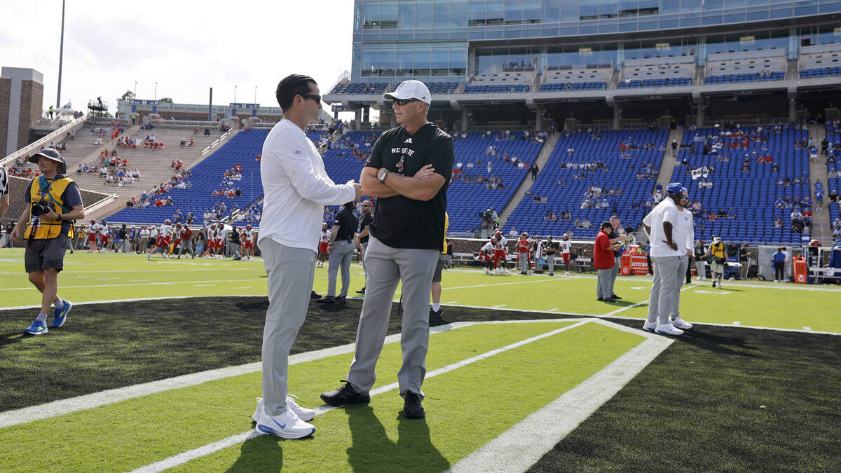 N.C. State head coach Dave Doeren talks with Duke head coach Manny Diaz before N.C. State’s game against Duke at Wallace Wade Stadium in Durham, N.C., Sat. Sept. 20, 2025