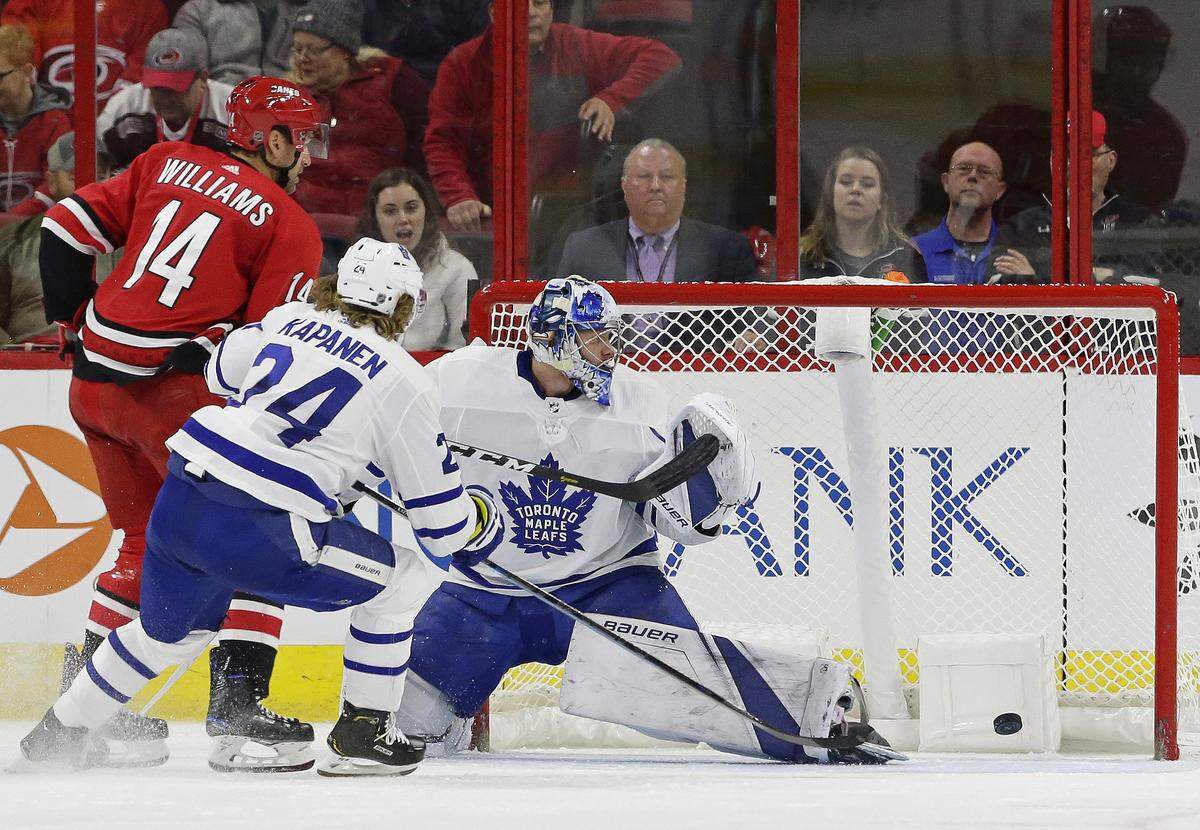 Carolina Hurricanes’ Justin Williams (14) scores against Toronto Maple Leafs goalie Frederik Andersen, of Denmark, while Kasperi Kapanen (24), of Finland, defends during the second period of an NHL hockey game in Raleigh, N.C., Tuesday, Dec. 11, 2018.